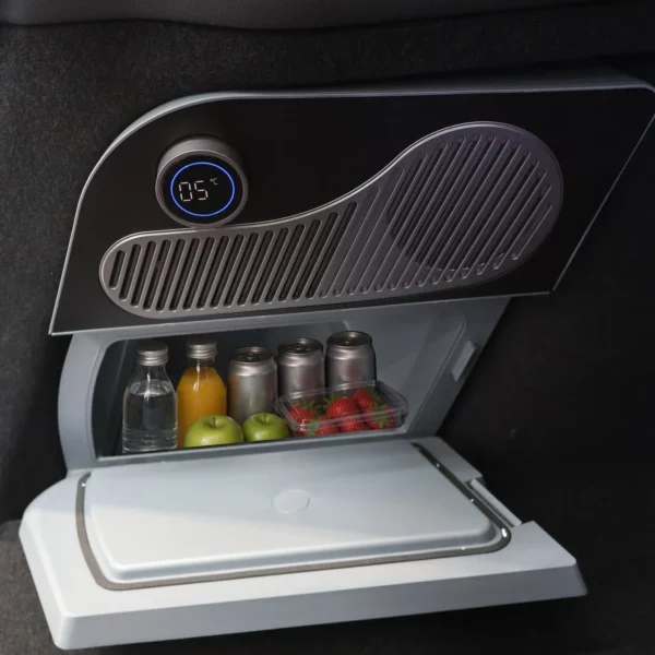 Glacière électrique ouverte vue de face dans le coffre d’une Tesla Model Y, afficheur à 5 °C, bac rempli de boissons