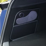 Glacière électrique fermée, façade noire affleurant la garniture gauche du coffre d’une Tesla Model Y