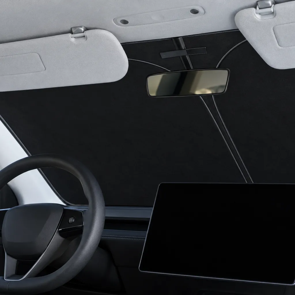Pare-soleil de pare-brise posé dans une Tesla Model 3 2024+ Highland Pare-soleil de pare-brise noir d’une seule pièce posé derrière le pare-brise d’une Tesla Model 3 Highland, vu depuis la place du conducteur