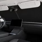 Habitacle d’une Tesla Model Y Juniper vu de la place passager, pare-brise couvert par le pare-soleil noir