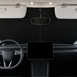 Pare-soleil de pare-brise noir d’une seule pièce posé derrière le pare-brise d’une Tesla Model Y Juniper, pare-soleil de la voiture rabattus, écran central éteint