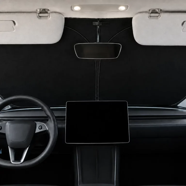 Pare-soleil de pare-brise noir d’une seule pièce posé derrière le pare-brise d’une Tesla Model Y Juniper, pare-soleil de la voiture rabattus, écran central éteint