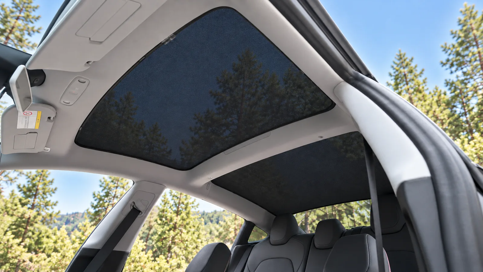 Pare-soleil en maille noire dans la Tesla Model 3 Highland, vue depuis la portière